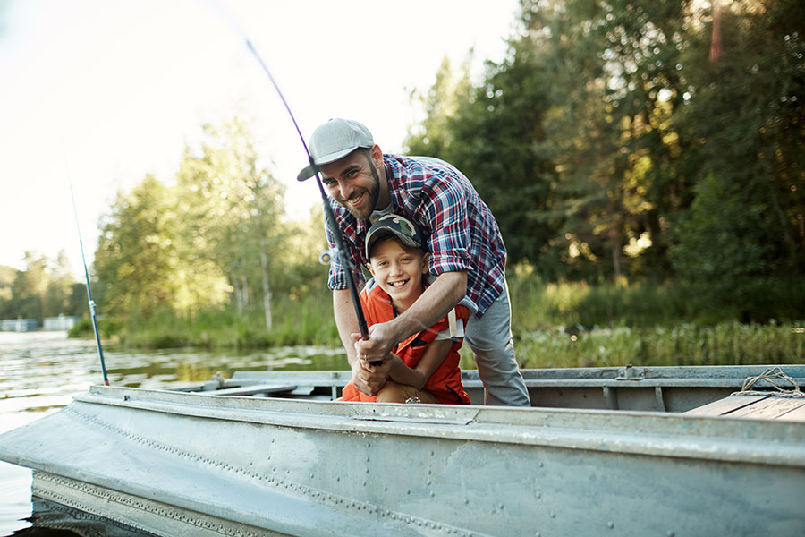 Personal Insurance - Happy Father and Son Fishing on a Boat in the Lake